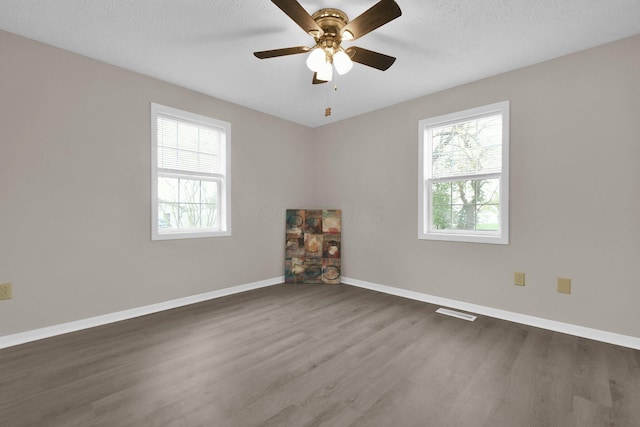 unfurnished room featuring dark hardwood / wood-style flooring and a wealth of natural light