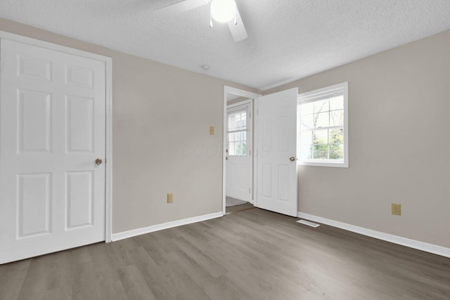 spare room featuring hardwood / wood-style floors, a textured ceiling, and ceiling fan