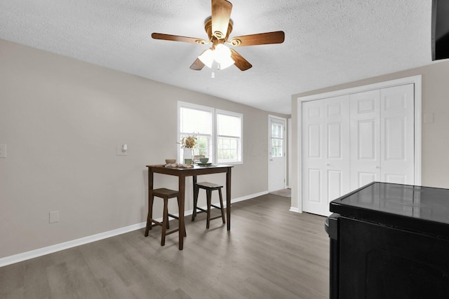 dining area featuring ceiling fan, dark hardwood / wood-style flooring, and a textured ceiling