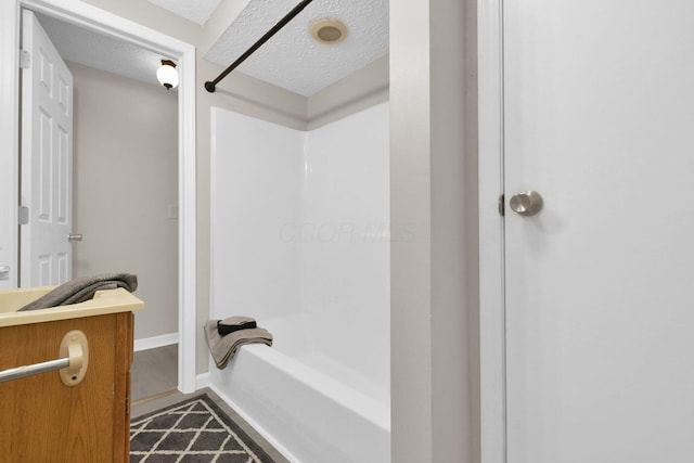 bathroom with a textured ceiling and washtub / shower combination