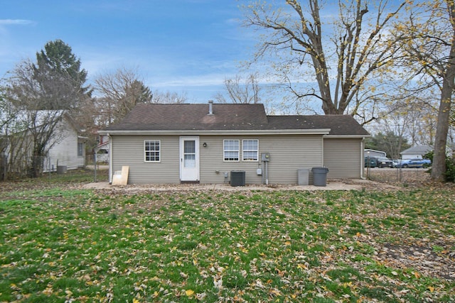 rear view of house with a lawn and central AC