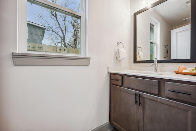 bathroom with plenty of natural light, vanity, and a textured ceiling