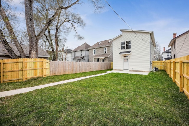 rear view of property with a lawn and central AC