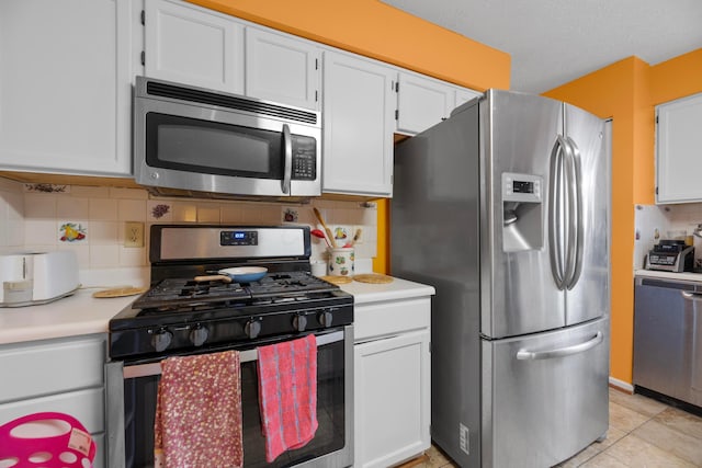 kitchen featuring decorative backsplash, appliances with stainless steel finishes, a textured ceiling, light tile patterned floors, and white cabinets