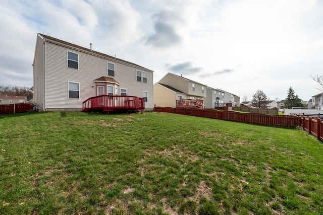 rear view of house with a lawn and a deck