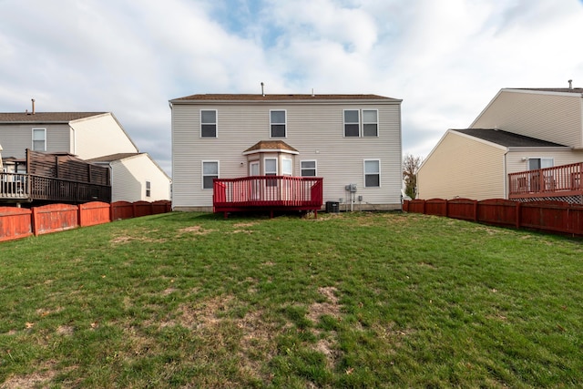 back of house with a lawn and a deck