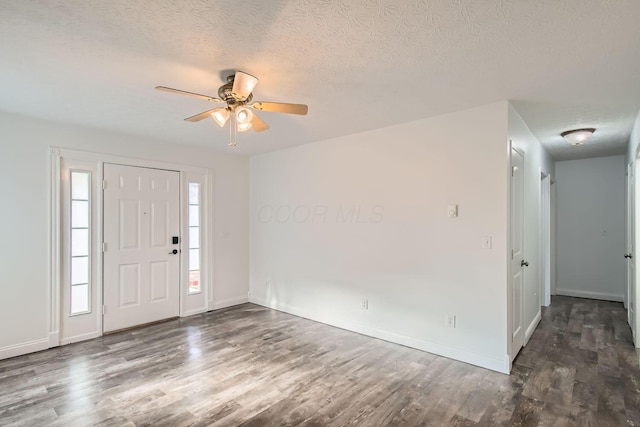 entryway with a textured ceiling, ceiling fan, and dark wood-type flooring