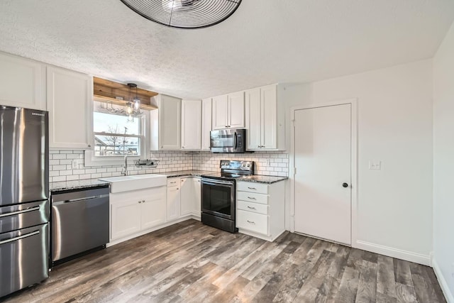 kitchen with white cabinets, sink, stainless steel appliances, and dark wood-type flooring