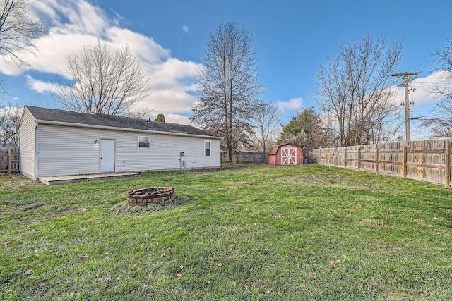 view of yard with a storage shed and an outdoor fire pit