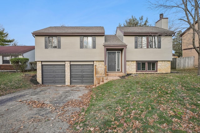 raised ranch with a garage and a front lawn