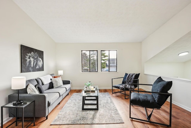 living room featuring light wood-type flooring and a textured ceiling