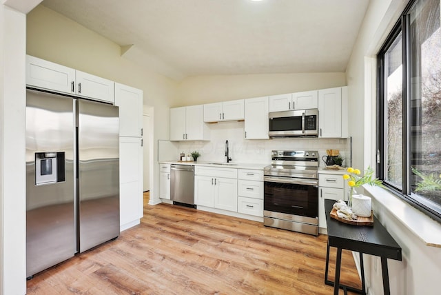 kitchen with backsplash, white cabinetry, sink, and appliances with stainless steel finishes