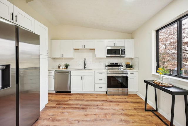 kitchen featuring appliances with stainless steel finishes, white cabinetry, and sink