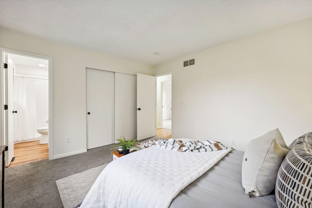 bedroom with carpet, ensuite bath, and a closet