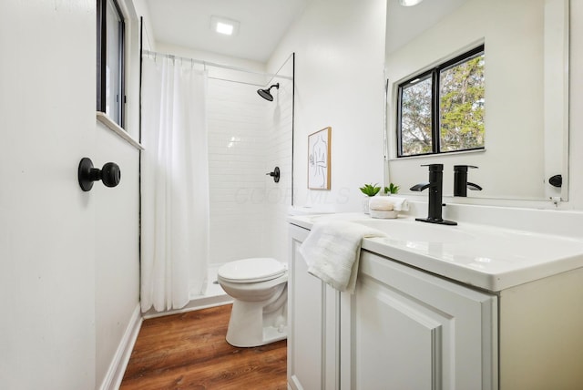 bathroom with wood-type flooring, vanity, toilet, and walk in shower