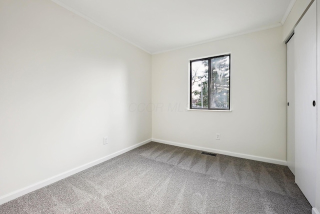 carpeted spare room with crown molding