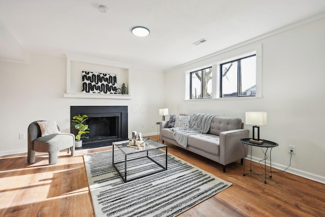 living room featuring hardwood / wood-style flooring and ornamental molding