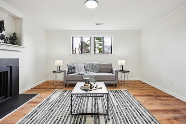 living room featuring wood-type flooring and crown molding