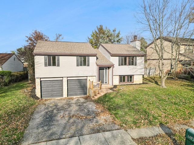 bi-level home featuring a garage and a front lawn