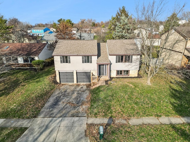 bi-level home featuring a garage and a front lawn