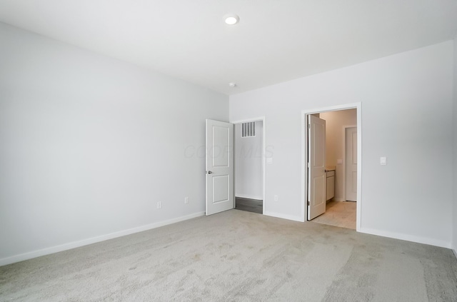 unfurnished bedroom with a spacious closet and light carpet