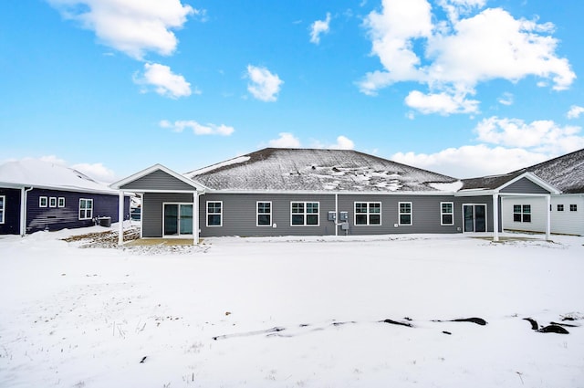 view of snow covered rear of property