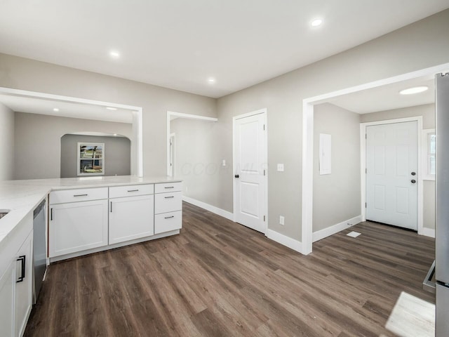 kitchen featuring dishwasher, dark hardwood / wood-style flooring, white cabinetry, and kitchen peninsula