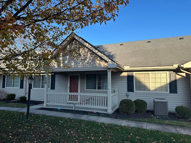 ranch-style home featuring central AC unit and a porch