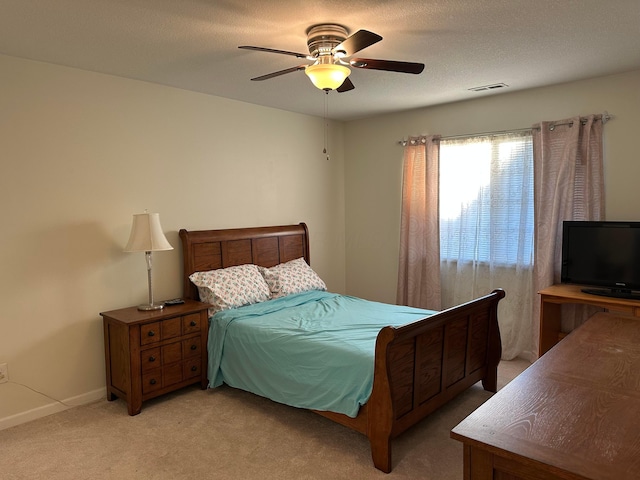 carpeted bedroom with a textured ceiling and ceiling fan