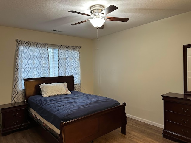 bedroom featuring a textured ceiling, dark hardwood / wood-style flooring, and ceiling fan