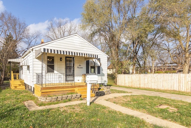 bungalow with covered porch and a front lawn