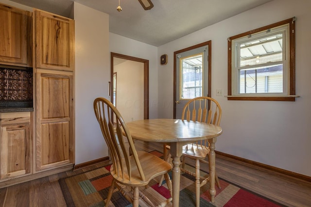 dining area with ceiling fan and dark wood-type flooring