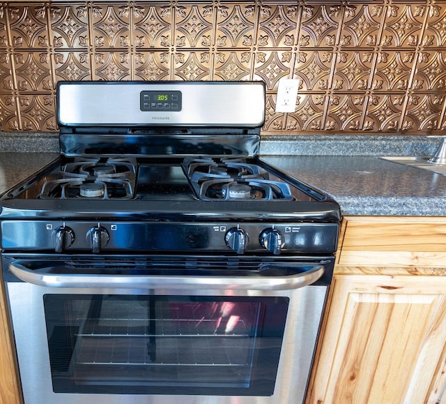 interior details with stainless steel gas stove and light brown cabinets