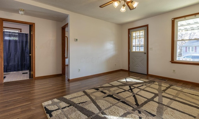 interior space with a textured ceiling, dark hardwood / wood-style floors, and ceiling fan