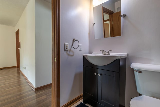 bathroom featuring hardwood / wood-style floors, vanity, and toilet