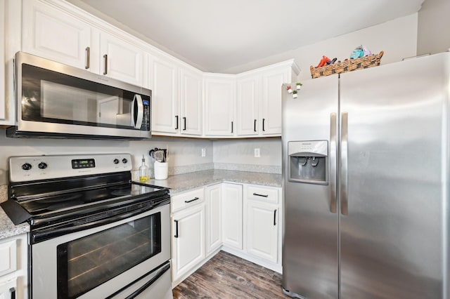 kitchen with light stone countertops, stainless steel appliances, white cabinetry, and dark hardwood / wood-style floors