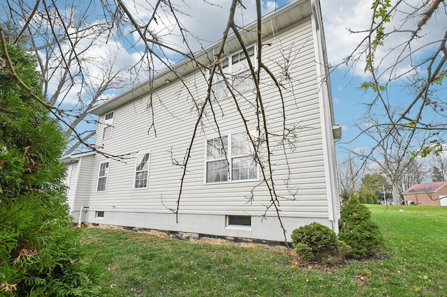 view of side of home with a yard