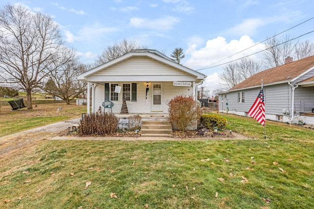 bungalow featuring covered porch and a front lawn