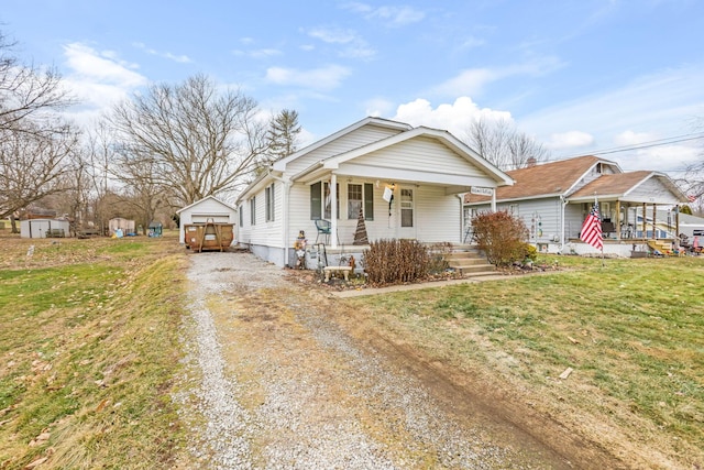 bungalow-style house featuring a storage shed, a front lawn, and covered porch