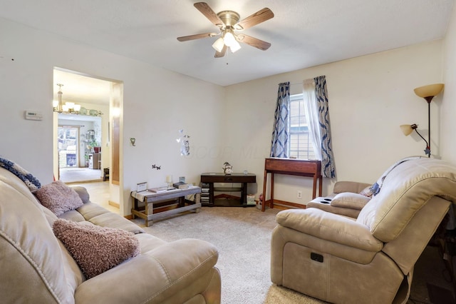 carpeted living room with ceiling fan with notable chandelier