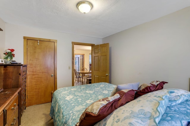 carpeted bedroom featuring a textured ceiling and a closet