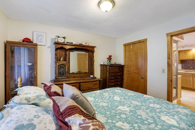 bedroom with a closet, sink, and a textured ceiling