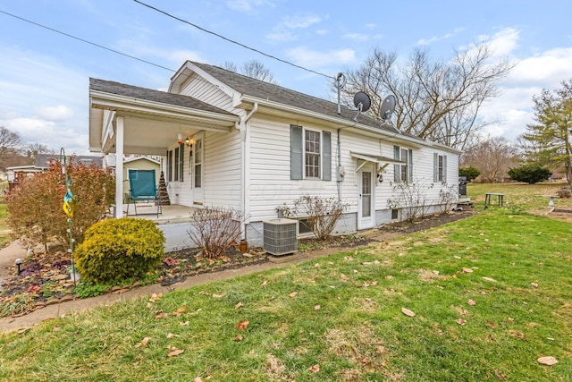 view of side of property with a lawn, central air condition unit, and a porch