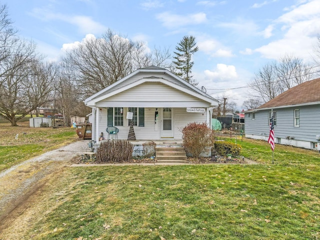 bungalow-style home with a front lawn and covered porch