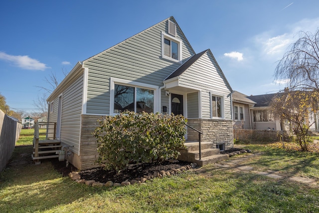 view of front of house featuring central air condition unit and a front lawn