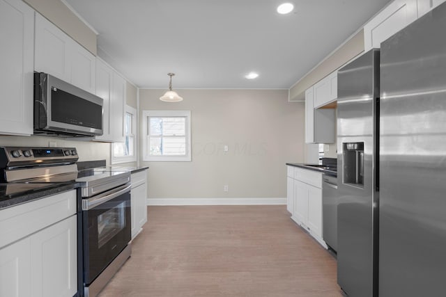 kitchen featuring white cabinets, appliances with stainless steel finishes, decorative light fixtures, and light hardwood / wood-style flooring