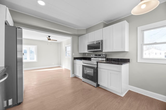 kitchen with white cabinets, ceiling fan, ornamental molding, light hardwood / wood-style floors, and stainless steel appliances