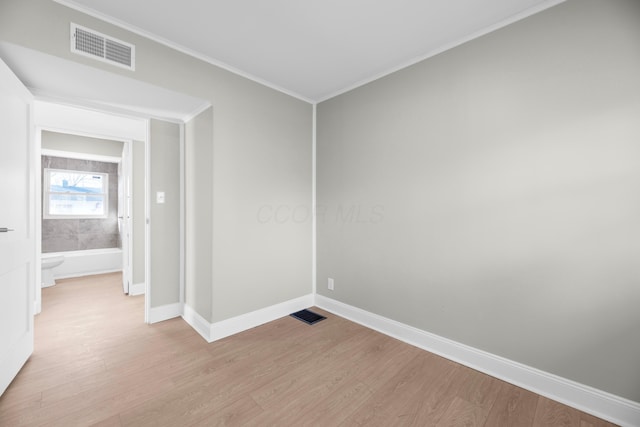 spare room featuring light hardwood / wood-style flooring and ornamental molding