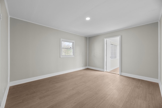 spare room with light hardwood / wood-style floors and crown molding