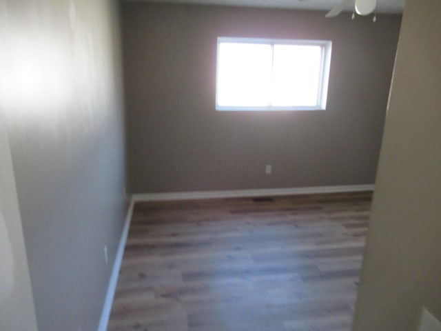 empty room with ceiling fan and wood-type flooring